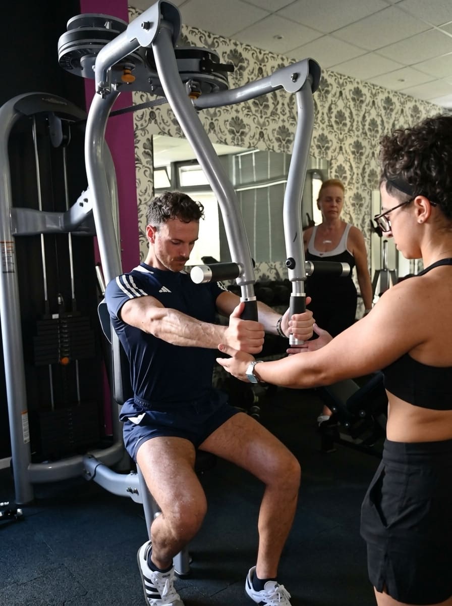 Sessione di personal training uno-a-uno in sala attrezzi
